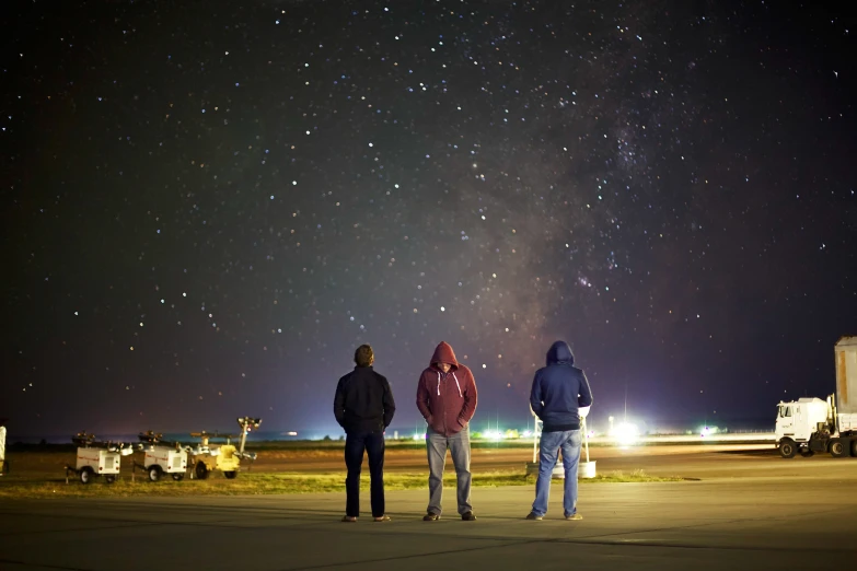 two people look up at the night sky as they watch the stars