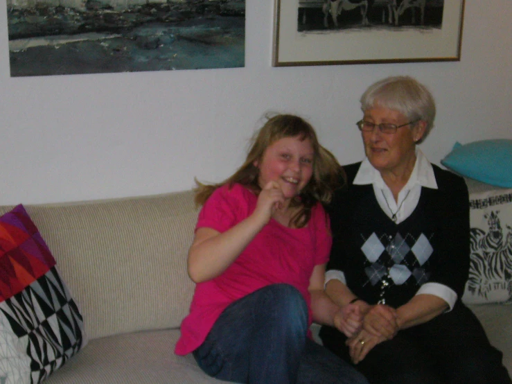 two girls and an older woman posing on the couch