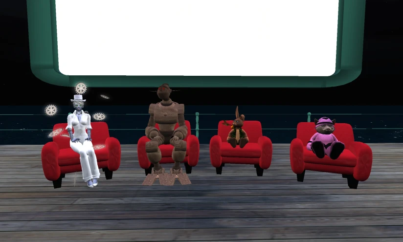 a group of four red chairs are facing a screen