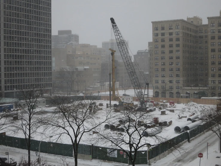 cranes in a building's yard with buildings on either side