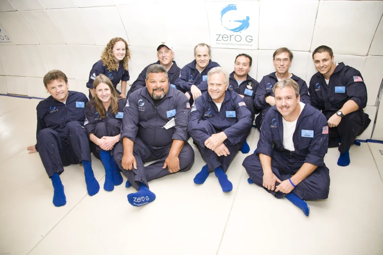 a group of men and women sitting on top of a space floor