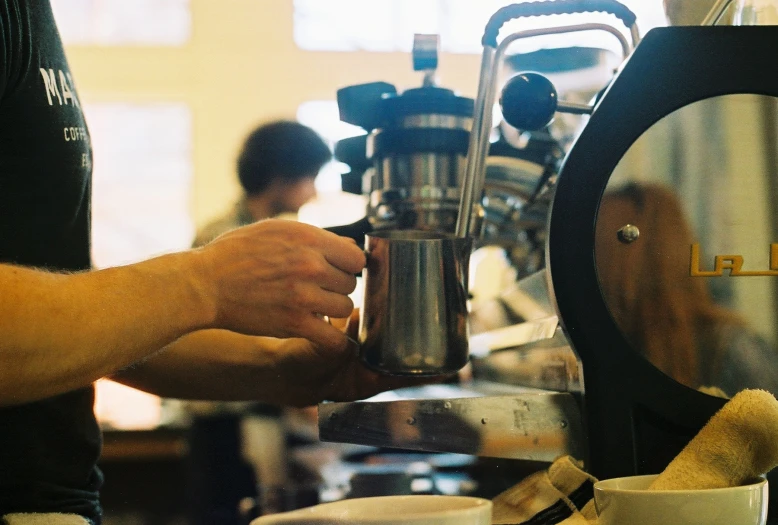 a man holding a coffee pot that has a large amount of stuff on it