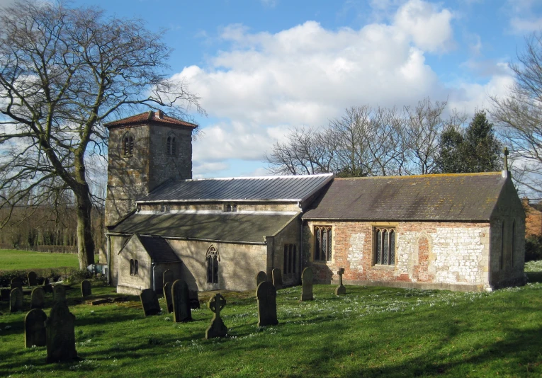 an old church with a cemetery next to it