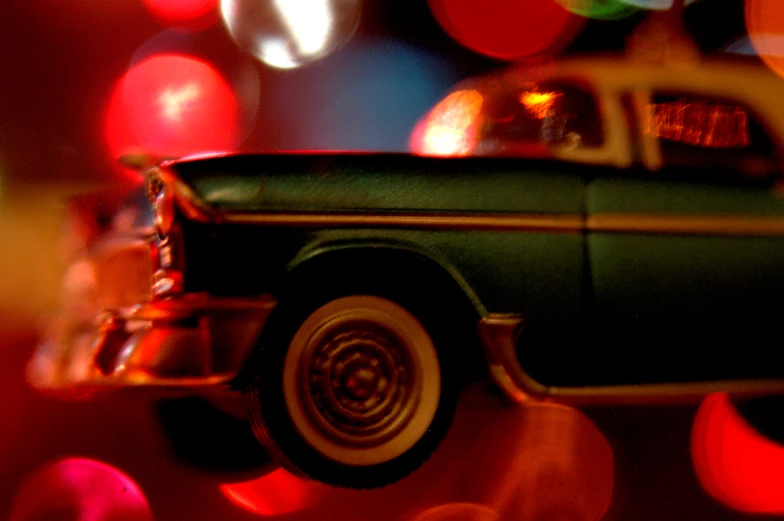 an antique car, illuminated by red and green lights
