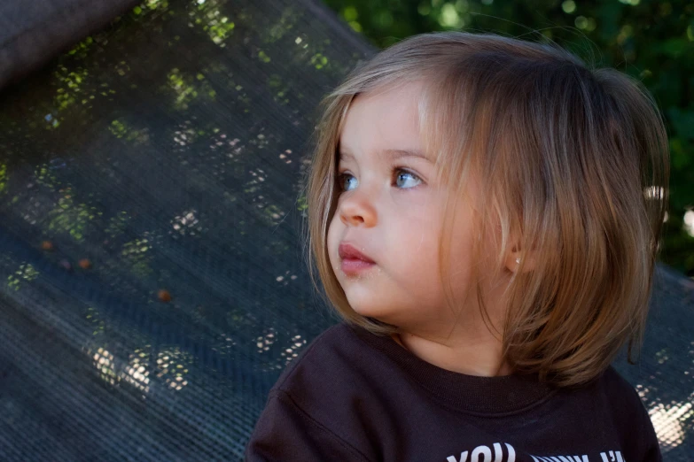 the little girl is sitting on a swing