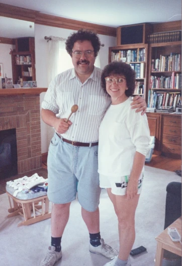 an older couple posing for a picture in front of a book shelf