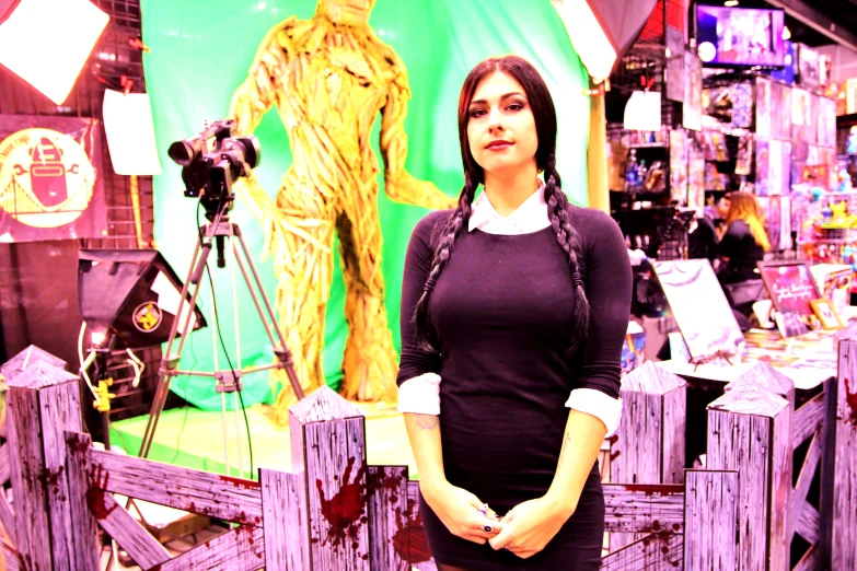 a woman in a black shirt is standing near a fence