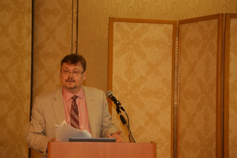 a man standing at a podium with a microphone in his hand