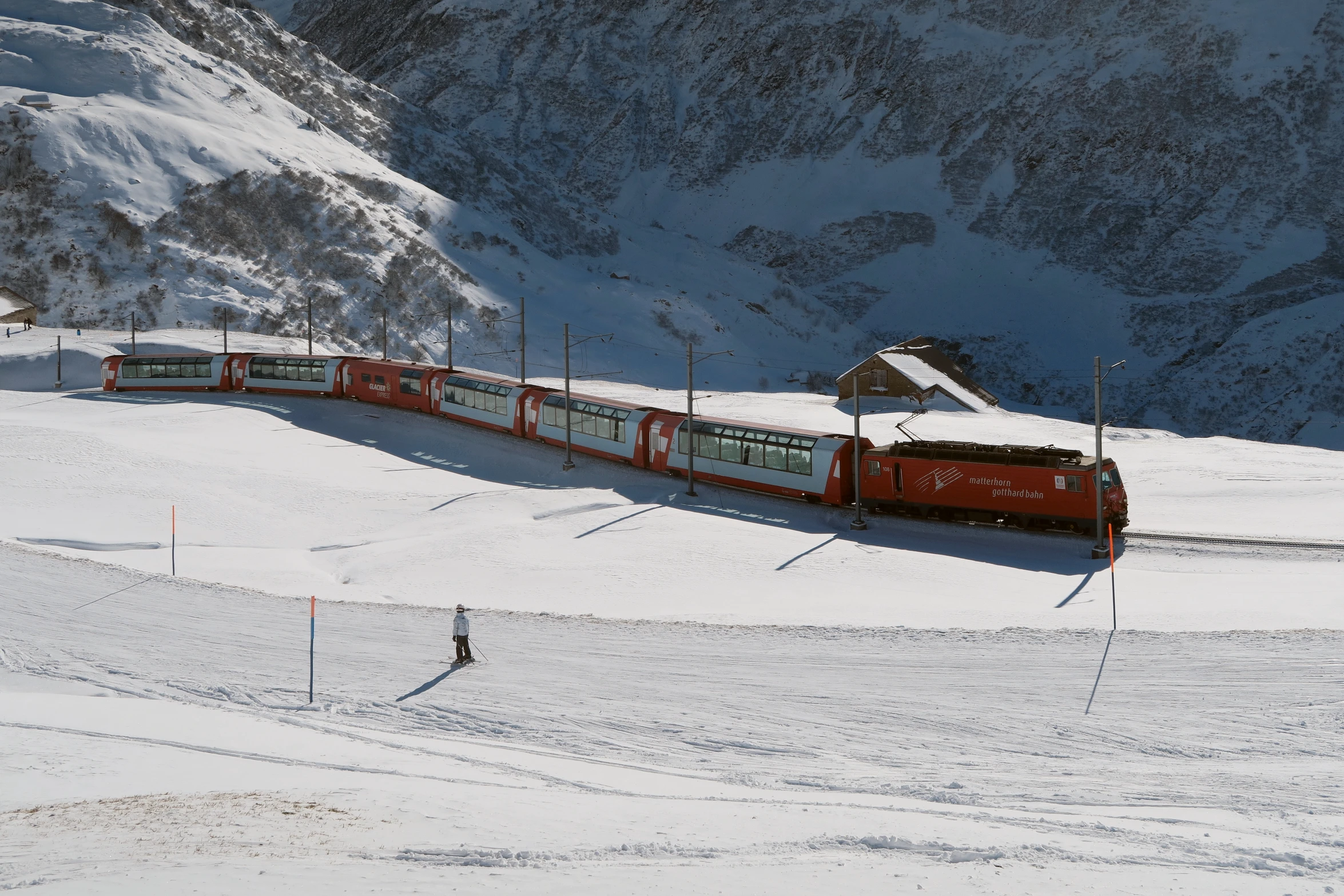 a red and white train traveling through the snow