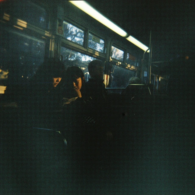 two people sitting on a bus in the dark