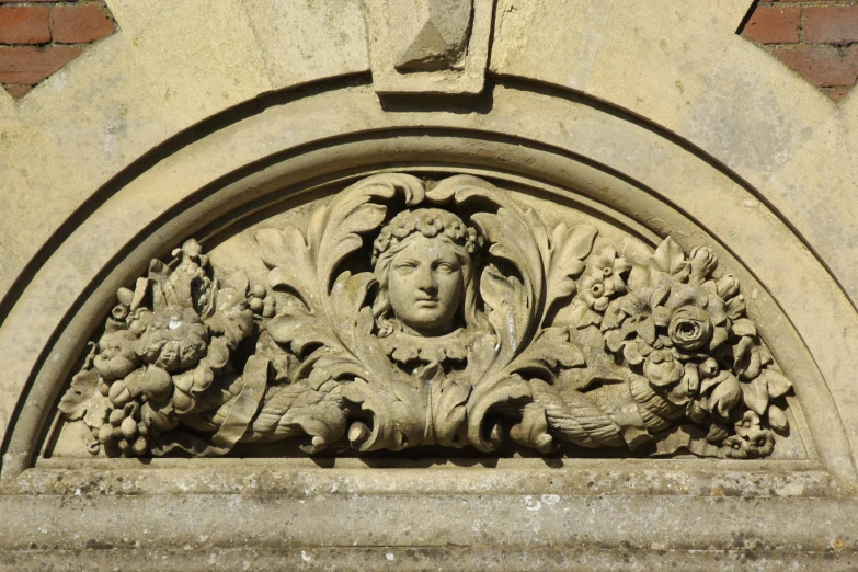 a carved stone of a girl with a flowered halo around her head