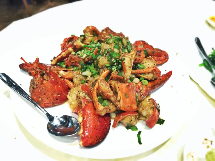 cooked and served crab with pea garnish on white plate