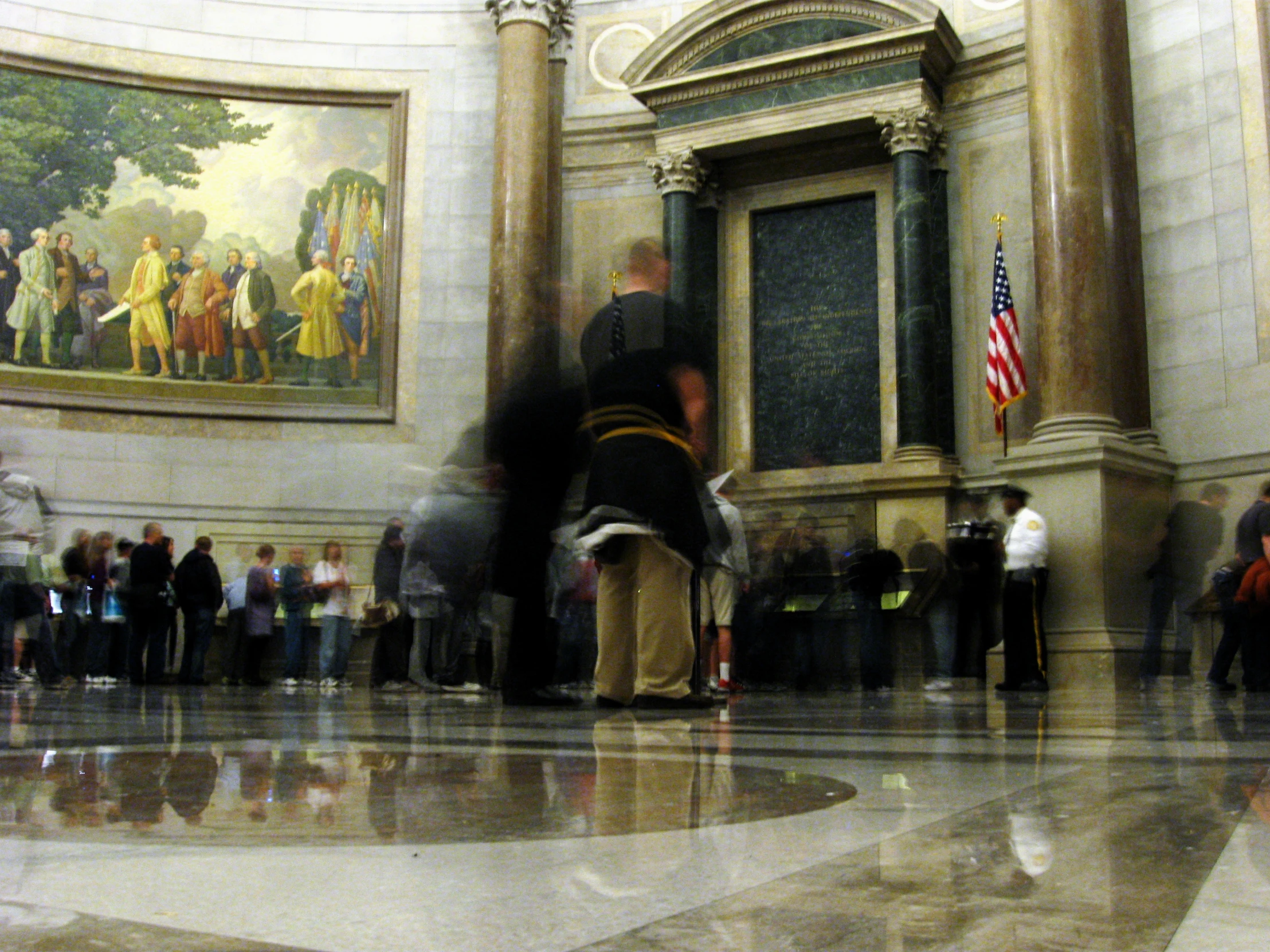 a group of people are walking by the wall paintings