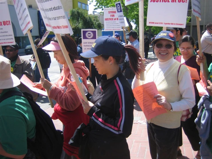 group of people holding signs standing in a crowd