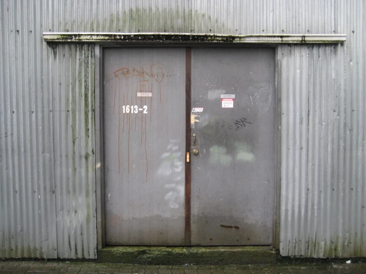 an old shed has a closed door and a set of signs