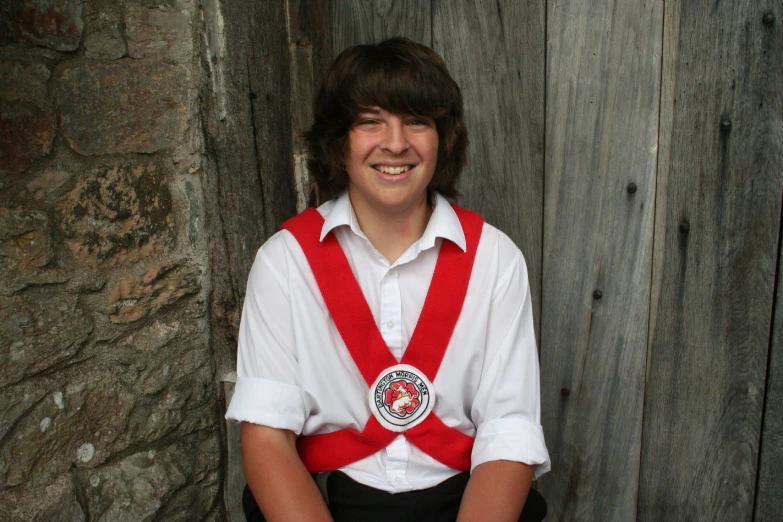 a boy is posing for a po with an award on his chest