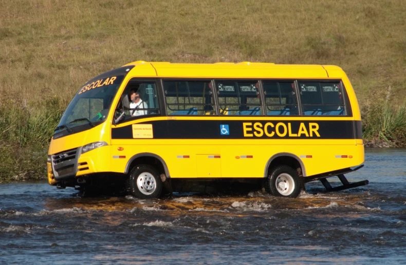 a yellow bus is in the middle of the water