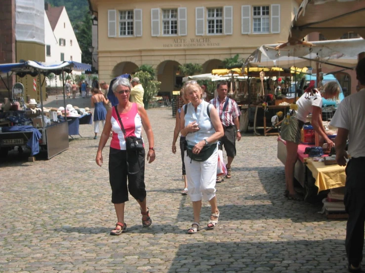 people walking through an open market, some in the foreground