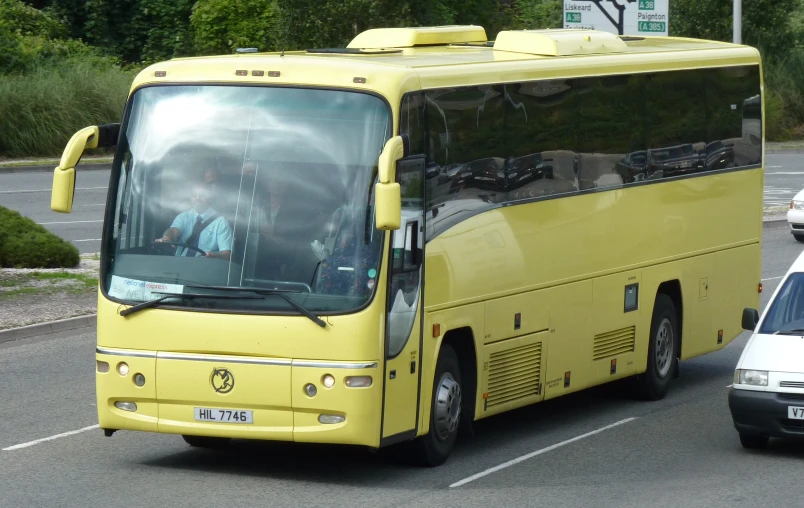 a yellow bus parked by the side of the road