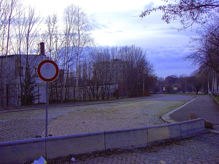 street signs sit near a paved surface in the twilight