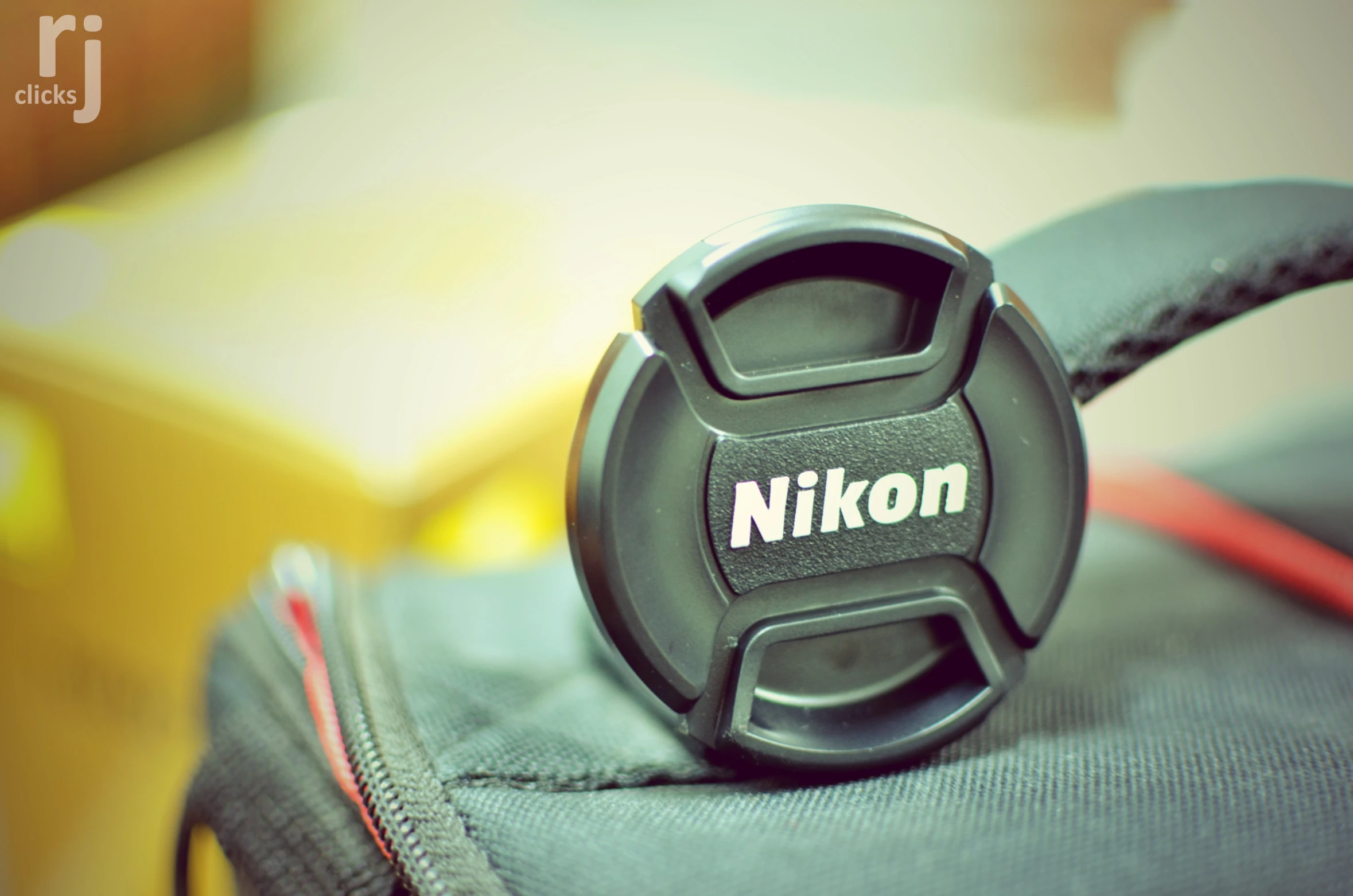 the lens cap on a backpack that's sitting on a couch