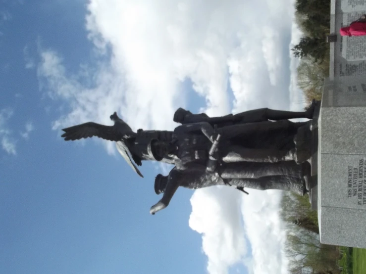 the statue in front of the monument is covered with birds