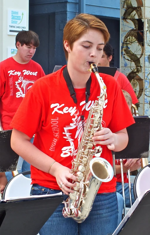 a man in a red shirt is playing saxophone