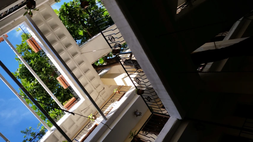 a balcony in a building with wrought iron railings and potted trees