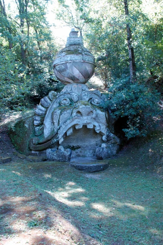 a stone fountain in front of trees