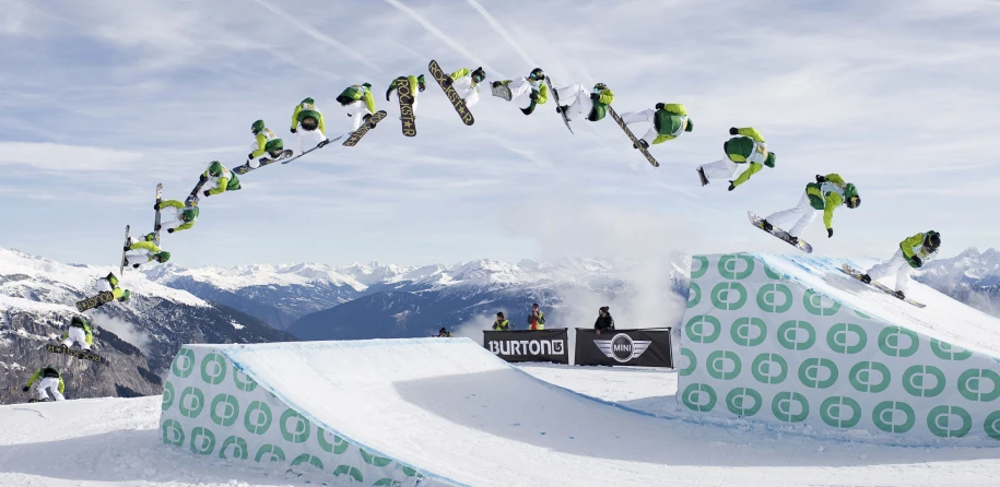 the man is snowboarding over a steep ramp on his own