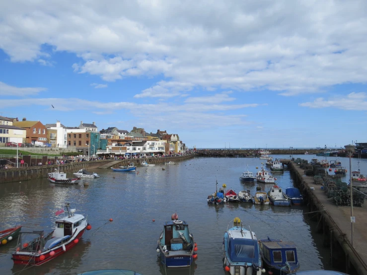 boats are parked in the marina while people watch from the pier