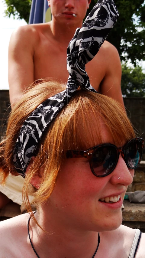 a woman is shown wearing a bandana in front of a man