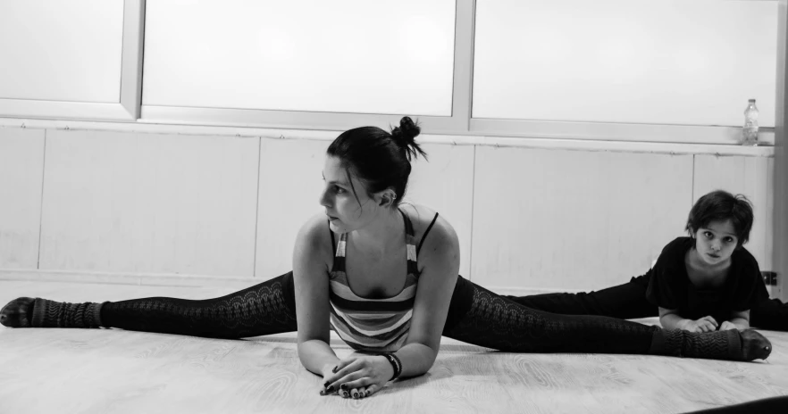 two women laying down on the floor with their hands together