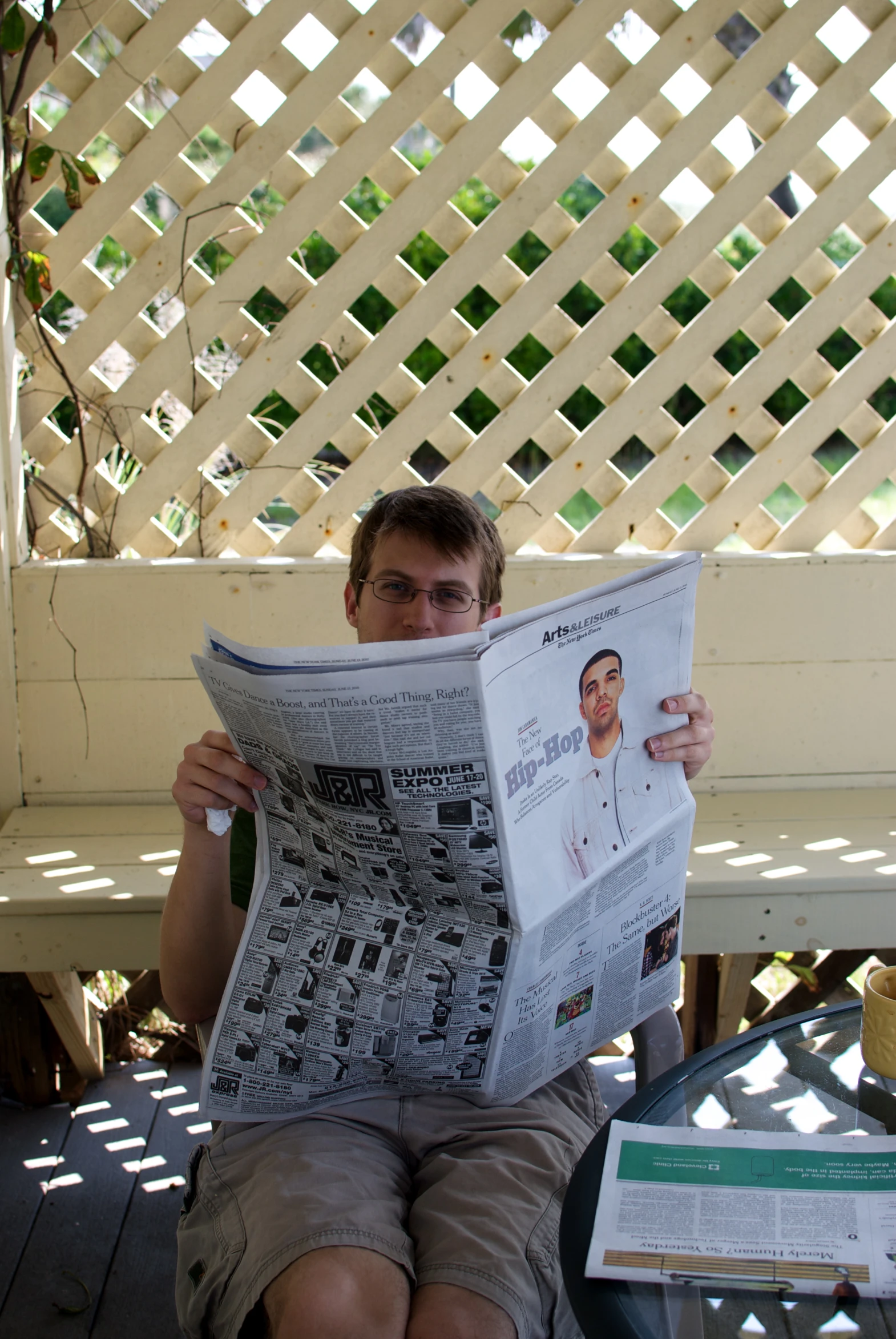 a man sitting outside reading a newspaper