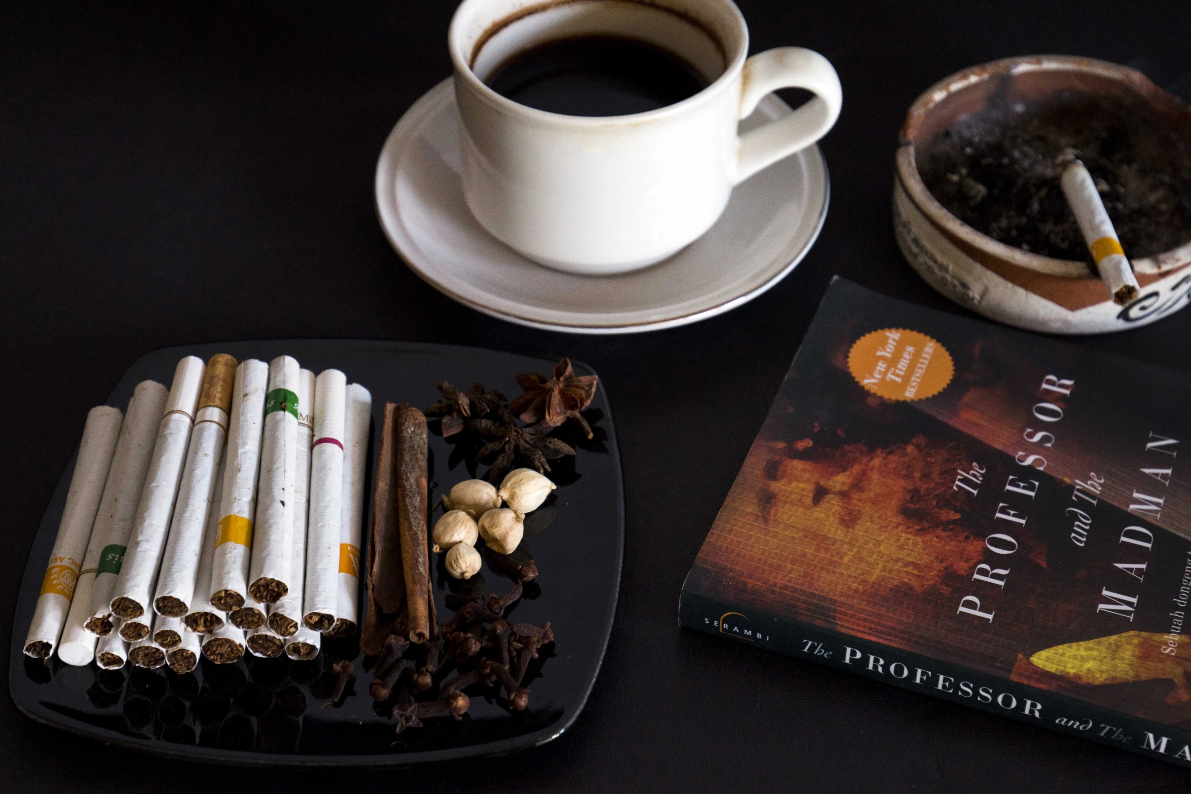 there is coffee, cigarettes and books on the table