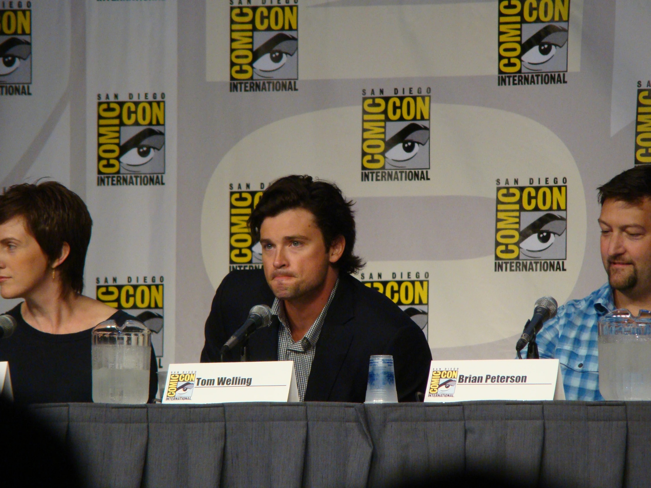 three people at a table having a press conference