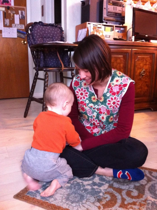 a woman sitting on the floor with her child