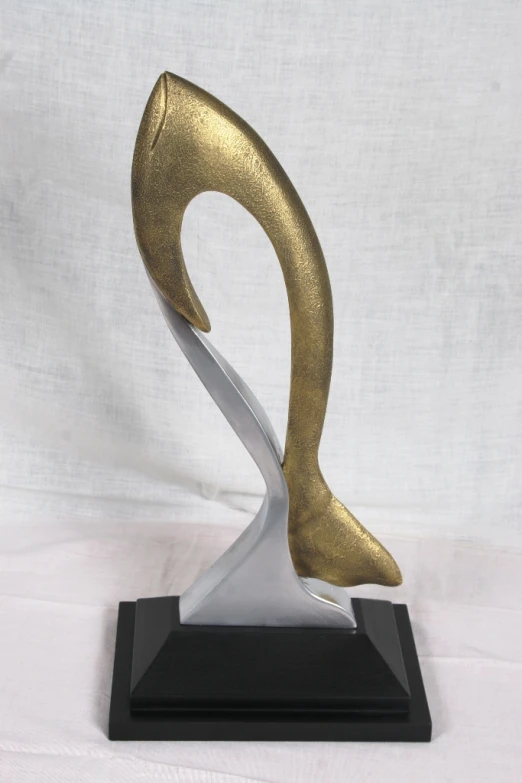there is a silver and gold sculpture on a black stand