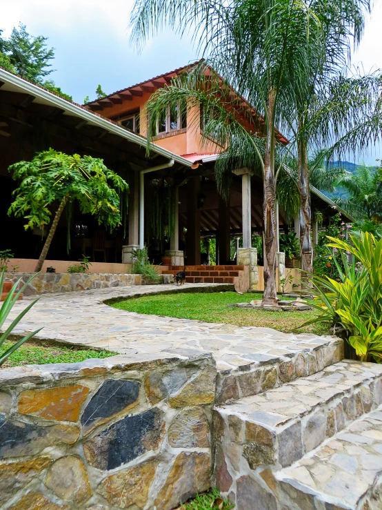 a home in the mountains with stone steps leading up to it