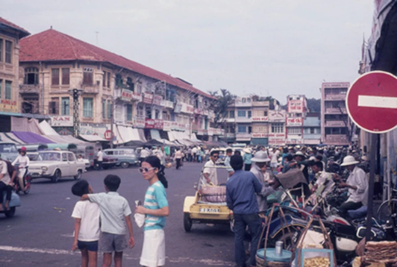 an oriental street scene with many cars and pedestrians