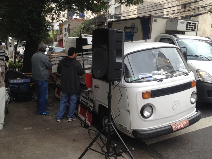 the truck is parked on the street near two men looking at it