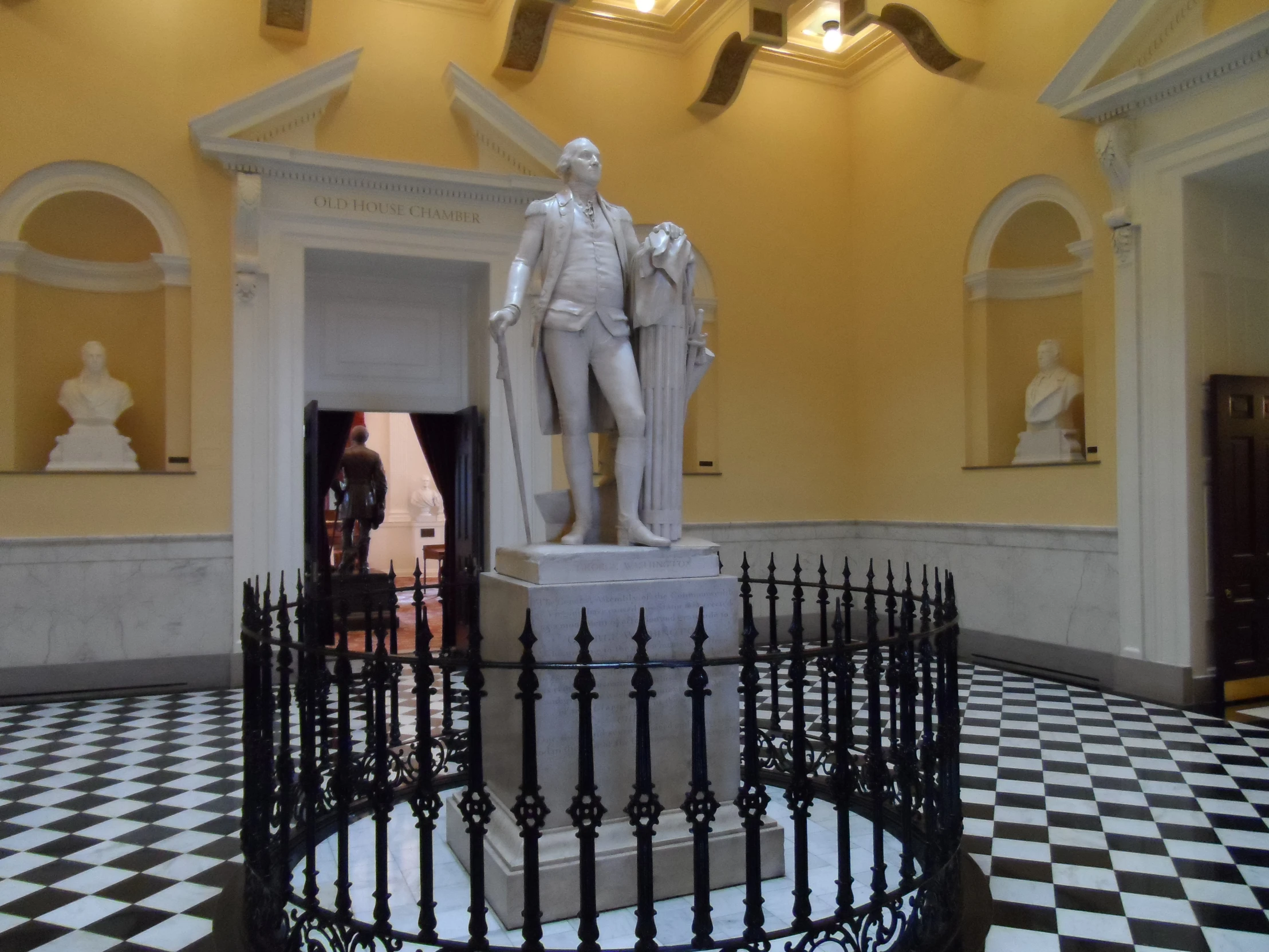 a metal sculpture sits in the middle of a room with some walls