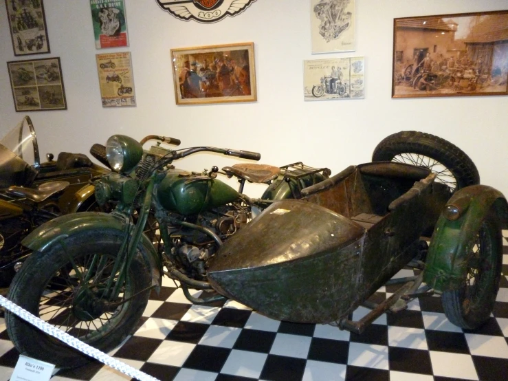 a motorcycle, sidecar, and car are on display