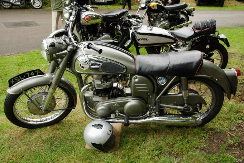 a row of motorcycles parked in a grassy field