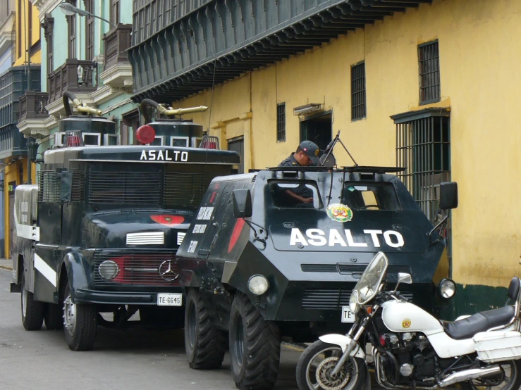 an army vehicle sits next to other vehicles