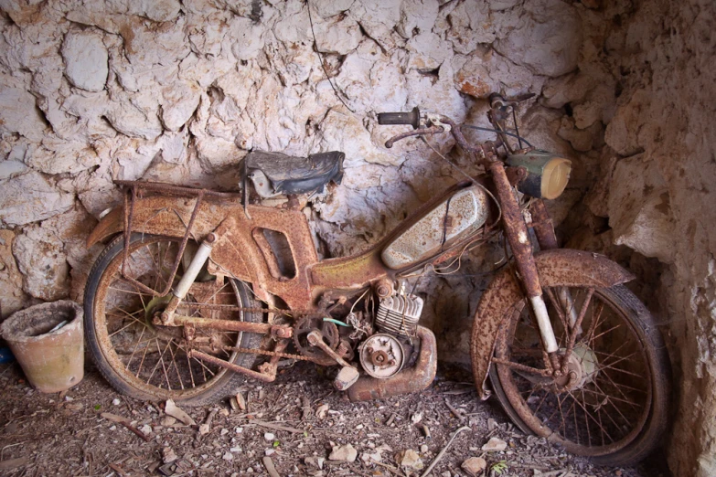 an old dirty bike that has been left out on the ground