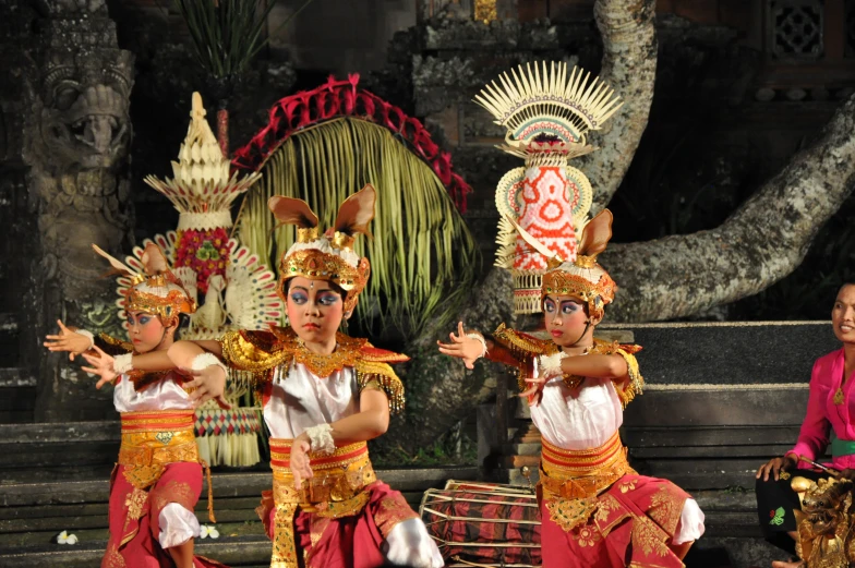 three young children are dancing in an artistic costume