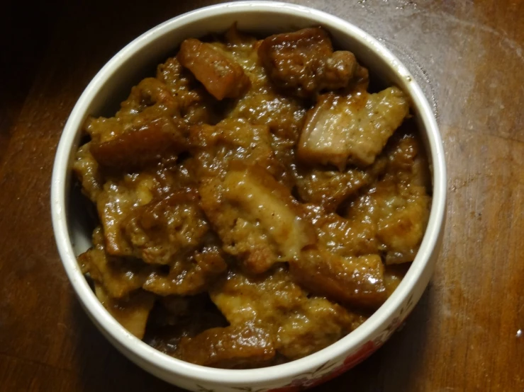 a bowl of food sits on top of a wooden table