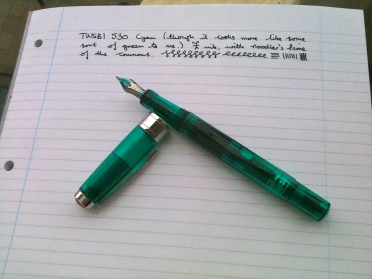 a fountain pen sitting on top of a notepad