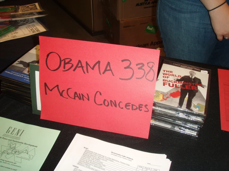 a sign for an obama campaign sitting on top of a table